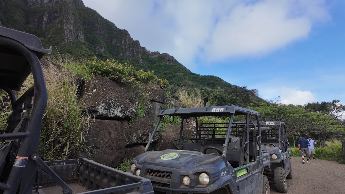 Team members riding ranch buggies below the cliffs at Kualoa Ranch in Hawaii